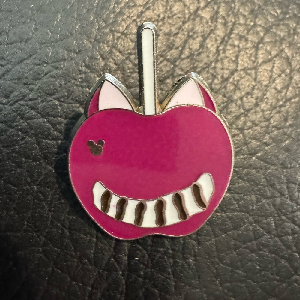 Disney Hidden Mickey pin shaped like a lollipop featuring the Cheshire Cat.